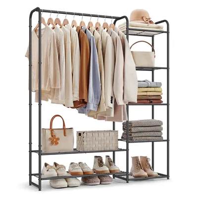 A freestanding metal garment rack with shelves, filled with clothes, bags, shoes, and folded towels.