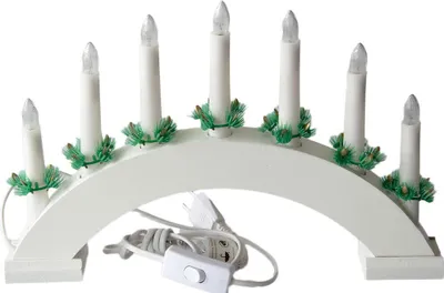 A white electric candle arch with seven candles and green decorative elements, shown on a white background.