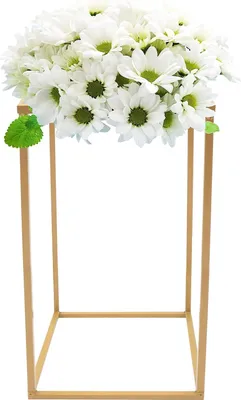A bouquet of white flowers with green leaves is displayed on a gold metal stand.