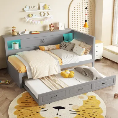 A child's bedroom with a grey daybed and pull-out trundle bed, decorated with playful elements.
