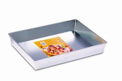 A rectangular baking pan with a textured bottom is shown on a white background. A colorful label with an image of baked goods is placed inside the pan.