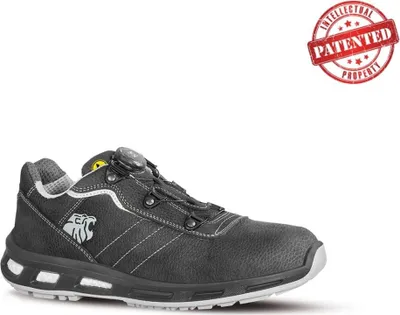 A black safety shoe with white stitching and a white sole, shown from the side against a white background. A red circular stamp with the text "INTELLECTUAL PROPERTY PATENTED" is in the upper right corner.
