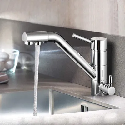 A chrome kitchen faucet with water running into a sink.