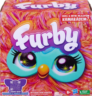The image shows the front packaging of a Furby toy. The packaging features a colorful, furry design with the Furby logo prominently displayed, along with its eyes and beak.