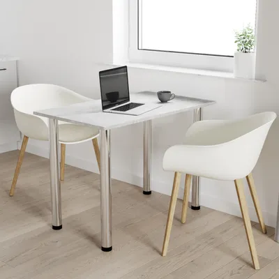 A small dining table with two chairs in a bright, modern room, with a laptop and coffee cup on the table.