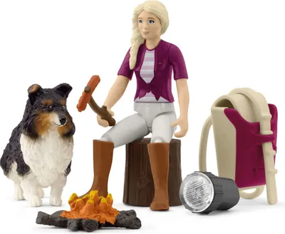 A toy set depicting a girl, a dog, a campfire, and camping accessories.