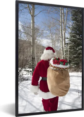 Produktbild von MuchoWow® Gerahmtes Poster Der Weihnachtsmann geht mit einem Sack voller Weihnachtsgeschenke durch einen Wald 60x90 cm - Poster mit Schwarzem Bilderrahmen Wandposter Rahmen Foto Bilder - Kunst