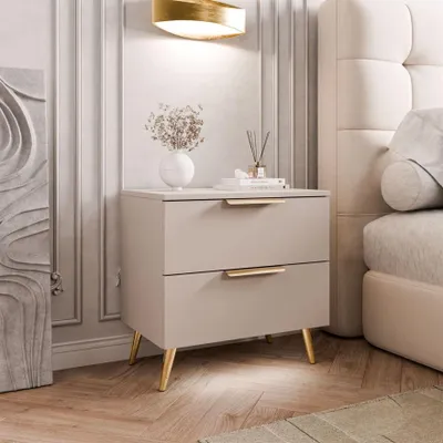 A bedside table with drawers next to a bed in a bedroom.