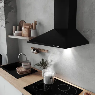 A modern kitchen scene with a black range hood above a stovetop where a pot is boiling.