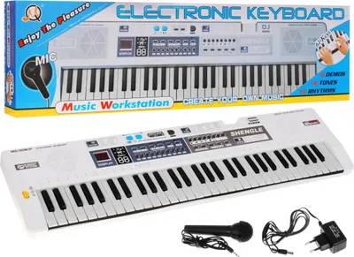 A white electronic keyboard with a microphone and power adapter, presented in a box with marketing text.