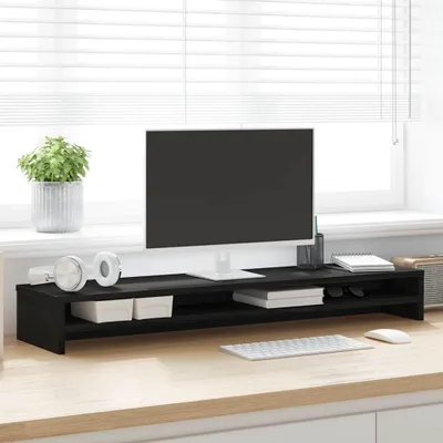 A monitor stand on a desk in front of a window with blinds.