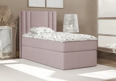 A single bed with a pink upholstered headboard and base, dressed with patterned bedding, in a room setting.