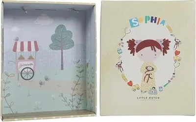 The image shows an open box with a scene inside and the lid of the box. The lid has a drawing of a girl and decorative elements.