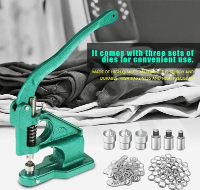 A green manual eyelet press machine with various accessories and fabric in the background.