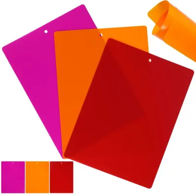 Three flexible cutting mats are arranged diagonally on a white background. A rolled-up orange mat is in the upper right corner. A smaller inset image at the bottom shows the three mats in solid colors.