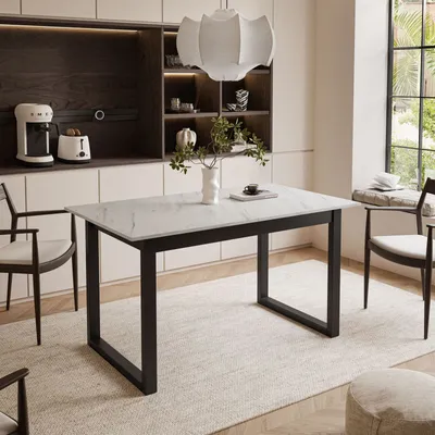 A dining table set up in a modern kitchen with chairs and a pendant light.