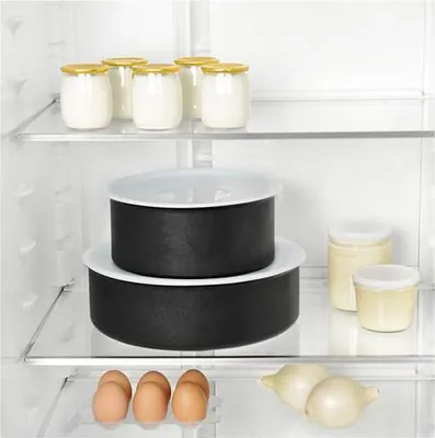 Inside a refrigerator, showing food items and cookware on shelves.