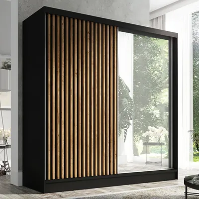 A modern wardrobe with a slatted wood front and a mirrored door, set in a well-lit room with a window view of greenery.