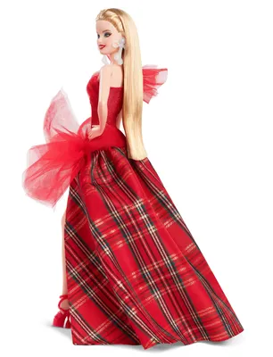 A Barbie doll wearing a red and black plaid gown with a large red bow on the back.