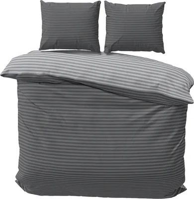 A neatly made bed with striped bedding and pillows.