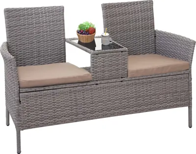 A poly-rattan bench with a small table and cushions, shown against a white background.