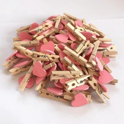 Productafbeelding van 50 roze houten wasknijpers in hartvorm - Decoratieve klemmen voor thuis, bruiloften en feestjes, geschikt voor knutselprojecten, het maken van vlaglijnen en het ophangen van foto's.