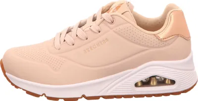 A side view of a beige Skechers sneaker.