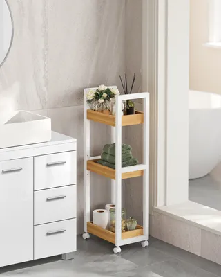A white and wood-colored rolling storage cart in a bathroom next to a vanity.