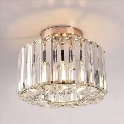 A close-up view of a crystal ceiling light fixture mounted on a white ceiling.