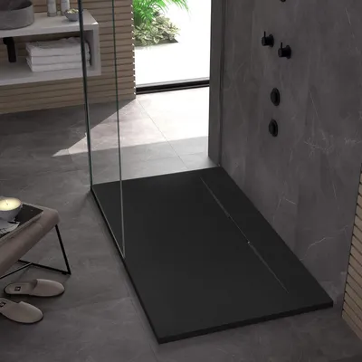 A modern bathroom with a black shower tray, gray tiled walls and floor, and a glass shower enclosure.