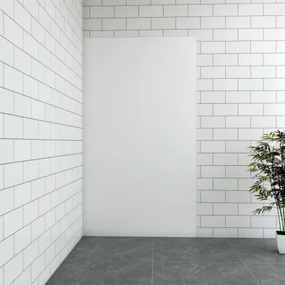 A corner of a room with white tiled walls and a gray tiled floor. A large white poster or panel is mounted on one wall, and a potted plant with green leaves is placed in the corner.
