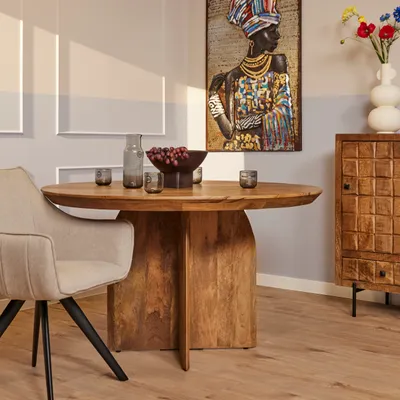 A dining room scene with a round wooden table, a chair, and a cabinet.