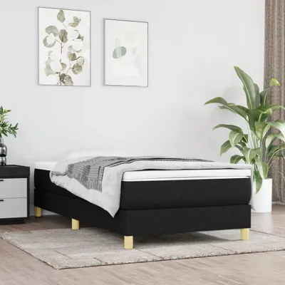 A bedroom scene featuring a black upholstered bed with a mattress and bedding.