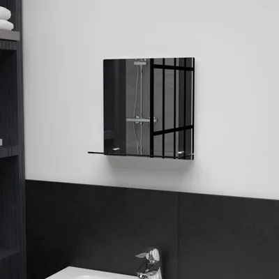 A bathroom scene with a mirror mounted on the wall above a black tiled surface.