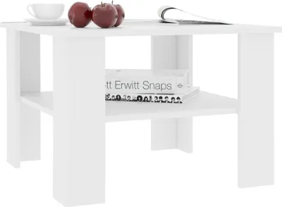 A white coffee table with books and apples on top.