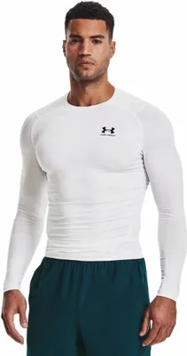 A man wearing a white long-sleeved shirt and dark green shorts.
