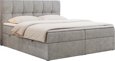 A grey upholstered boxspring bed with a headboard and bedding, shown against a white background.