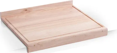 A wooden cutting board with a raised edge and a groove around the perimeter, placed on a white surface.
