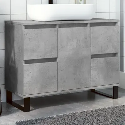 A concrete-look bathroom vanity with a white sink on top, set against a tiled wall.