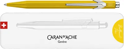 A yellow Caran d'Ache ballpoint pen and its packaging.