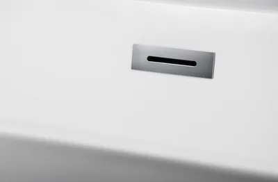 A close-up view of a white bathtub with a silver drain.
