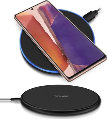A smartphone is placed on a wireless charging pad, with another charging pad shown below.