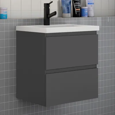 A modern bathroom vanity with a sink and faucet, set against a tiled wall.