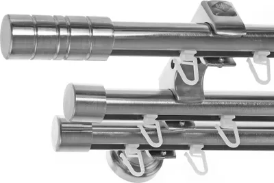 A close-up view of a triple curtain rod system with mounting brackets and curtain hooks.