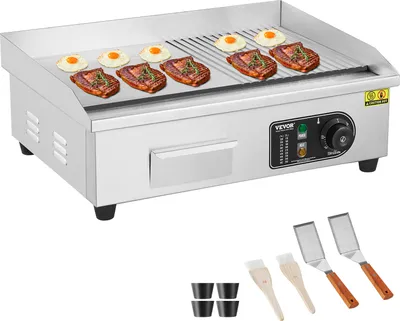 A commercial electric griddle with food cooking on it, along with accessories.