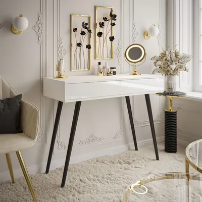 A white console table with two drawers, adorned with black floral wall art and decorative items, set in a luxurious room with decorative wall molding.