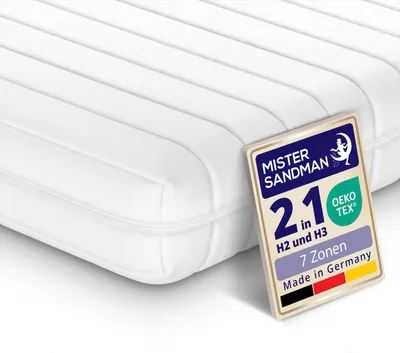 A close-up, slightly angled view of a white mattress with a label attached to the side.