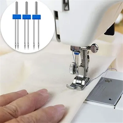 Close-up of sewing needles with a sewing machine in the background.
