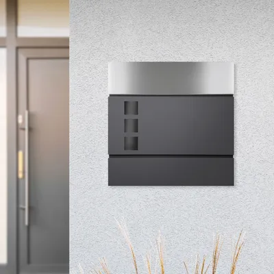 A modern mailbox mounted on a textured wall next to a door.