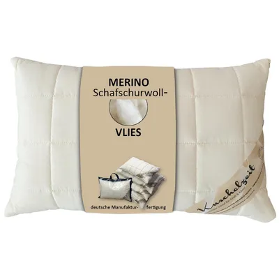 A cream-colored pillow with a brown label attached to the front.
